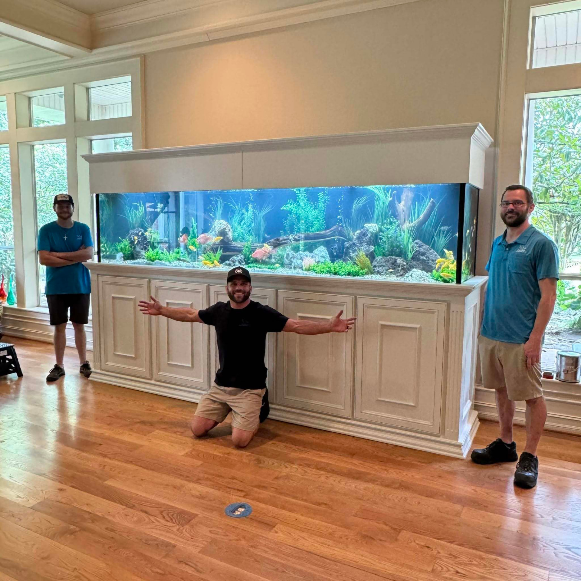 Cody and the Limitless Aquariums crew beside a large custom freshwater aquarium
